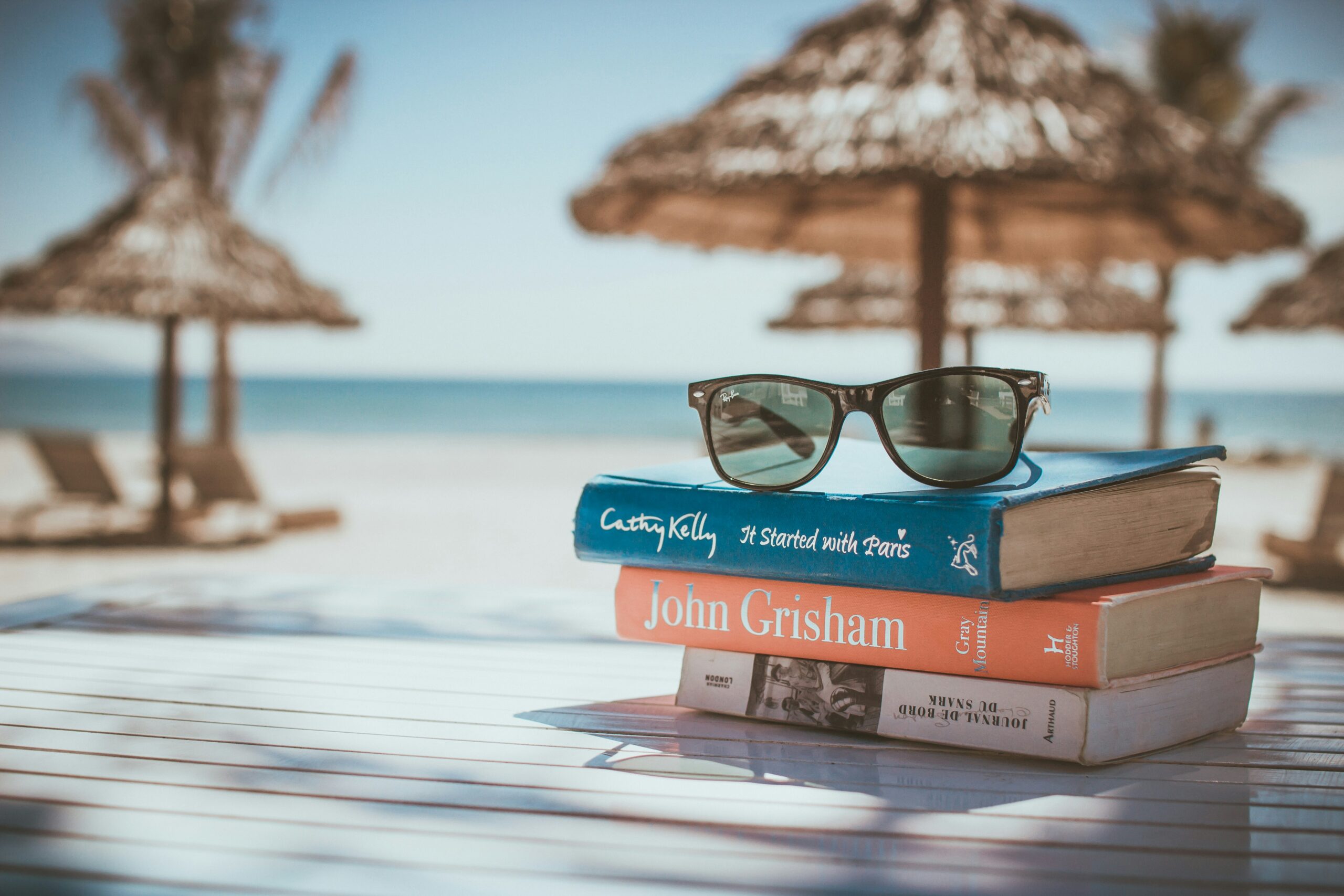 A stack of books in a cabana on the beach