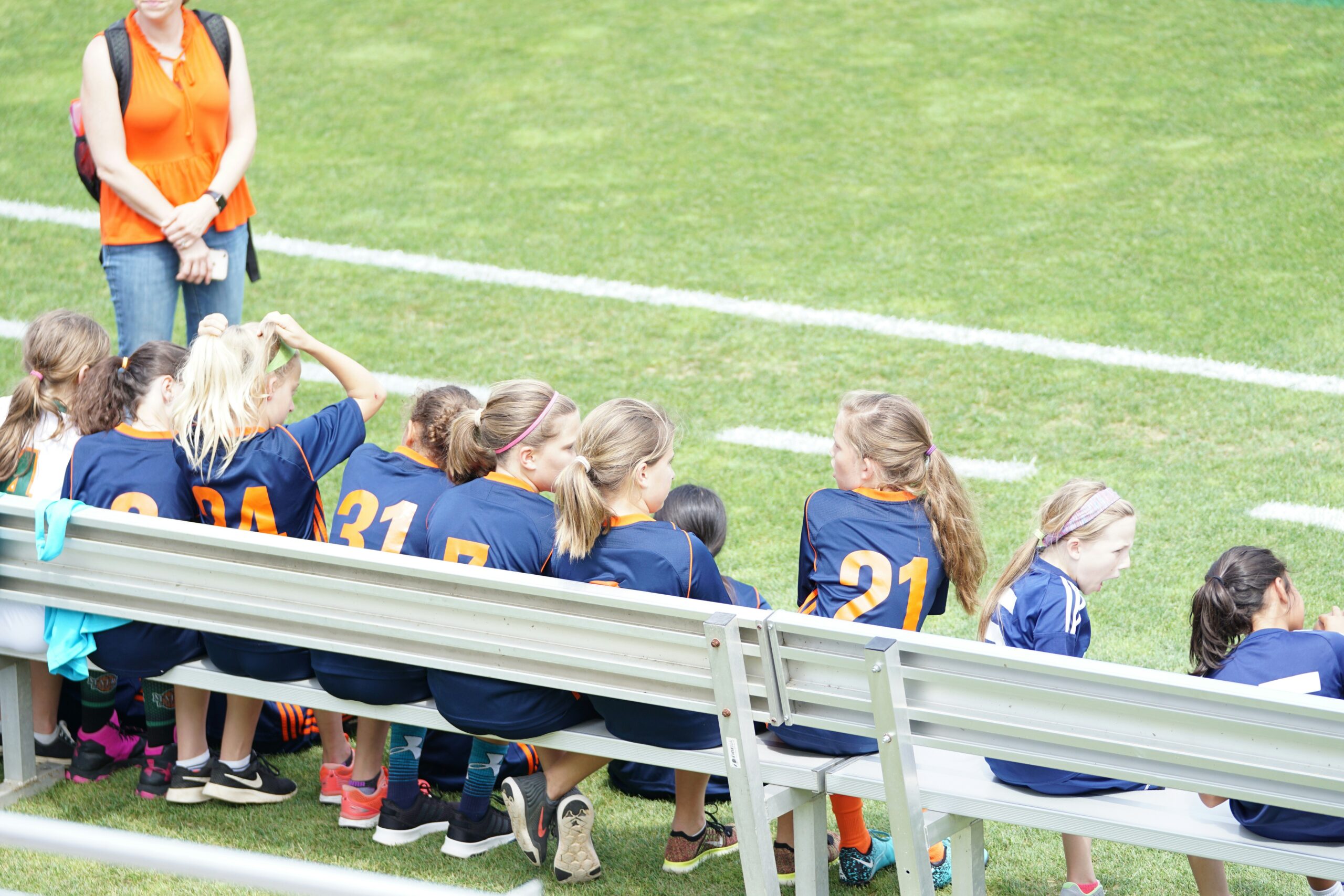 a soccer team sits o the sidelines waiting to play