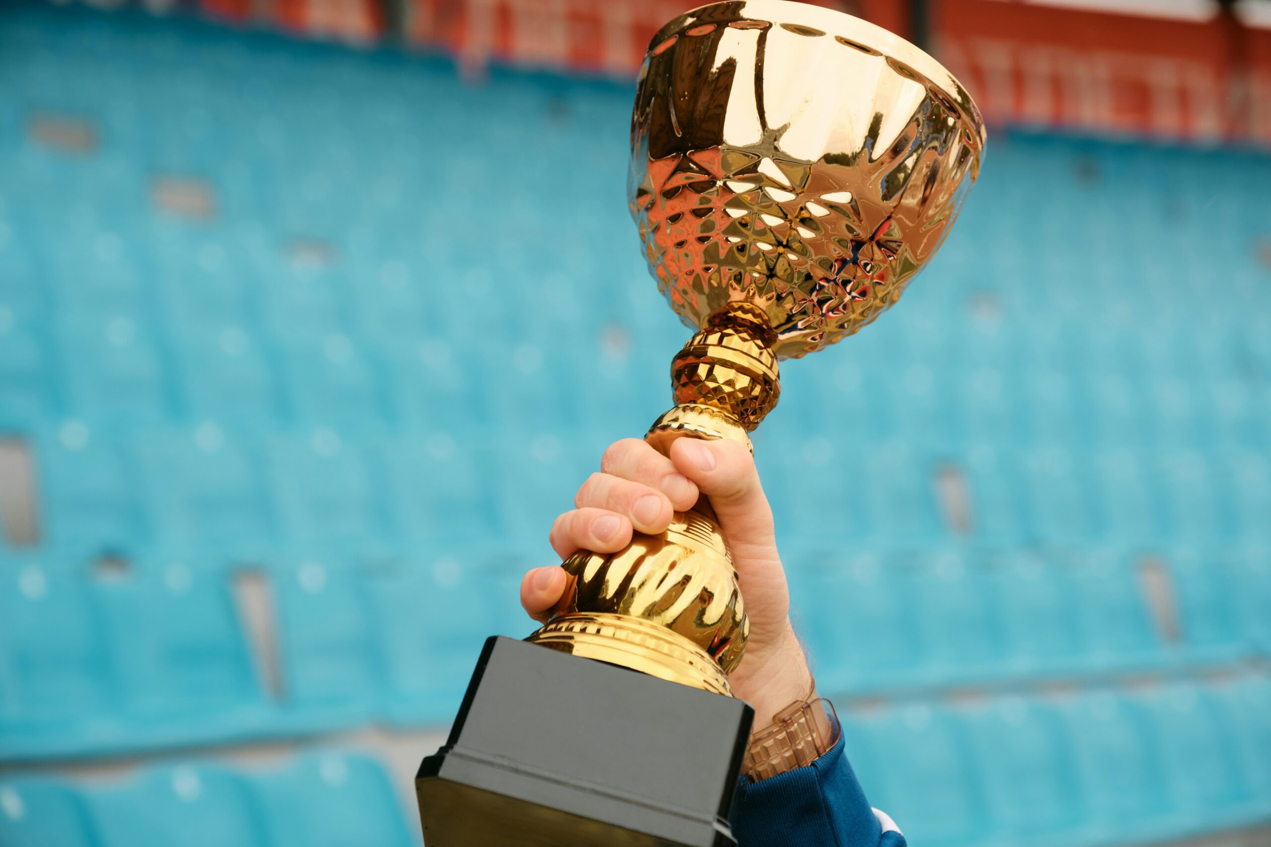 A person holds a golden trophy aloft to symbolise winning a charity sweepstakes